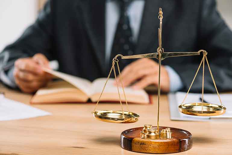 Cán cân công lý trên bàn làm việc của luật sư